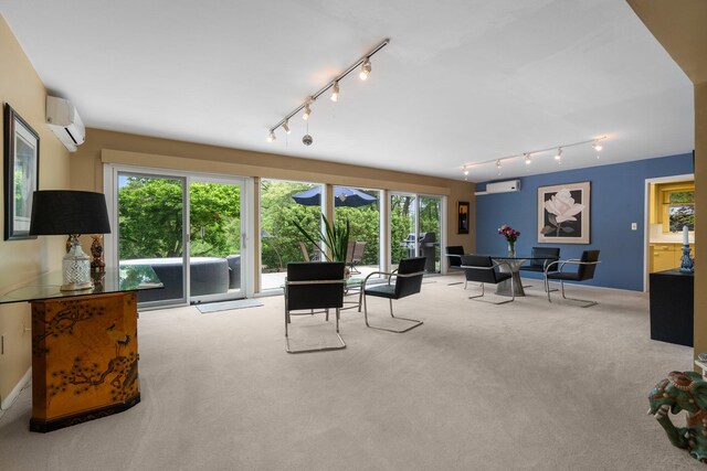 living room with track lighting, carpet floors, and a wall mounted air conditioner