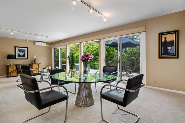 carpeted dining area featuring an AC wall unit and rail lighting