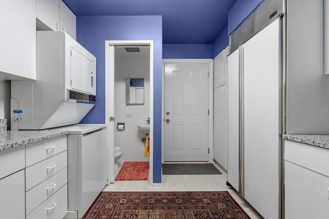 kitchen with light wood-type flooring and white cabinetry