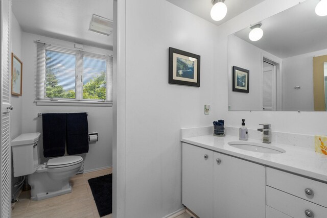 bathroom featuring hardwood / wood-style floors, toilet, and vanity