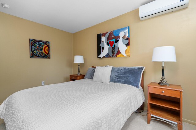 carpeted bedroom featuring an AC wall unit