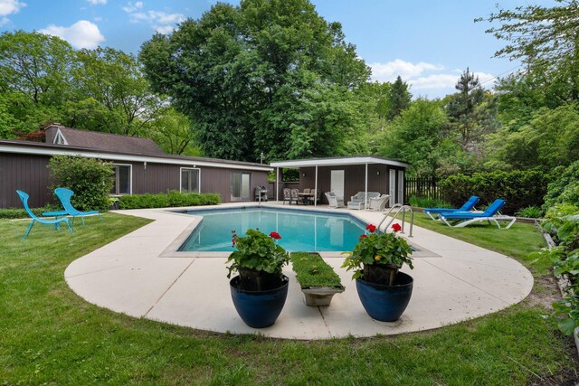 view of swimming pool featuring a patio area and a yard