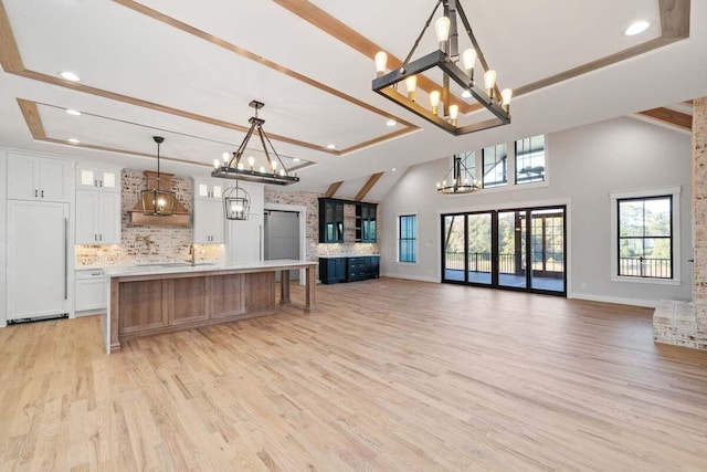 kitchen featuring a spacious island, white cabinetry, tasteful backsplash, paneled fridge, and pendant lighting