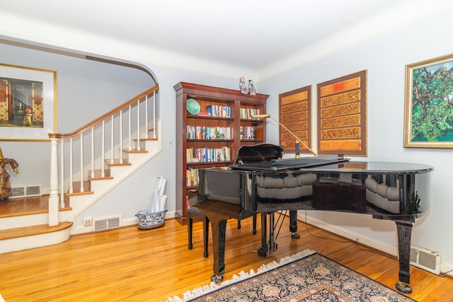 miscellaneous room with hardwood / wood-style floors and ornamental molding