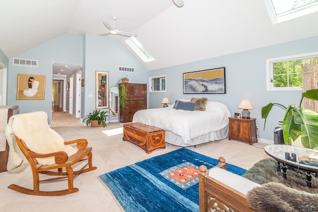 carpeted bedroom featuring high vaulted ceiling, ceiling fan, and a skylight