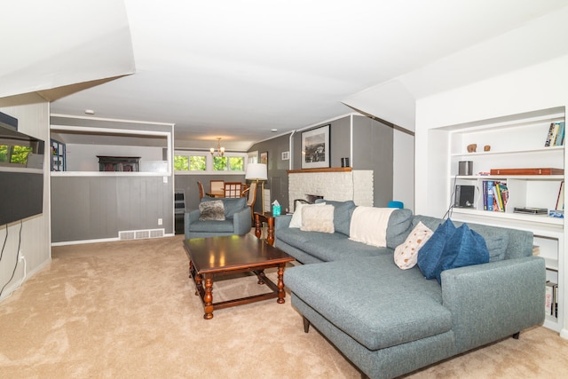 carpeted living room with a notable chandelier