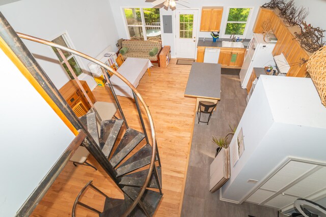 staircase with light wood-type flooring and ceiling fan