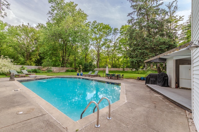 view of swimming pool with a patio and a lawn