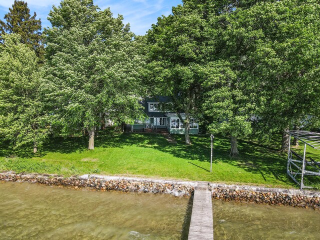 back of house featuring a water view and a yard