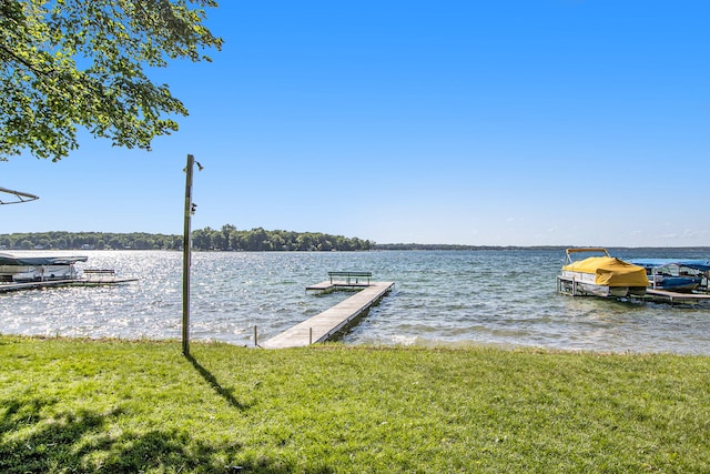 view of dock with a yard and a water view