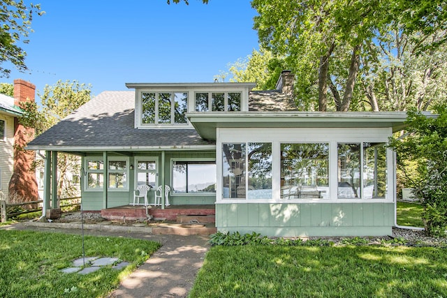 view of front of property with a front lawn and a sunroom