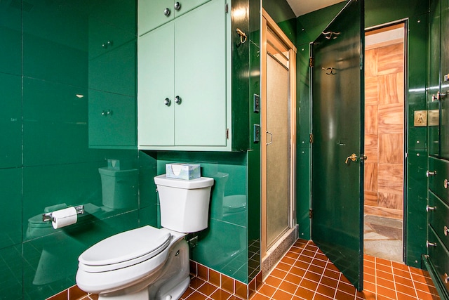 bathroom with tile patterned floors, a shower with shower door, and toilet