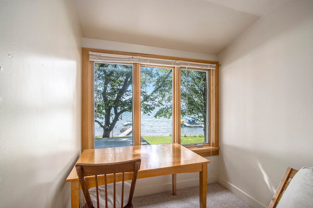 office space featuring vaulted ceiling, carpet flooring, a water view, and a wealth of natural light