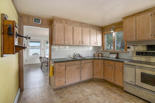 kitchen with a healthy amount of sunlight, sink, tasteful backsplash, and range with electric stovetop