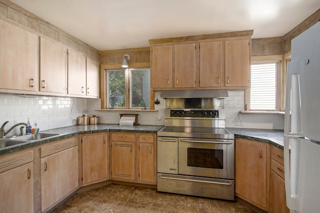 kitchen featuring white fridge, a healthy amount of sunlight, sink, and stainless steel electric range oven