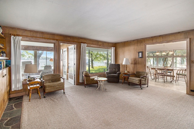 carpeted living room with wood walls