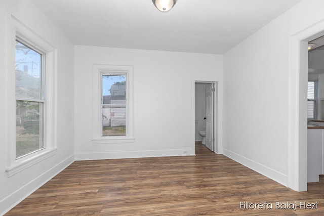 unfurnished room with a wealth of natural light and dark hardwood / wood-style flooring