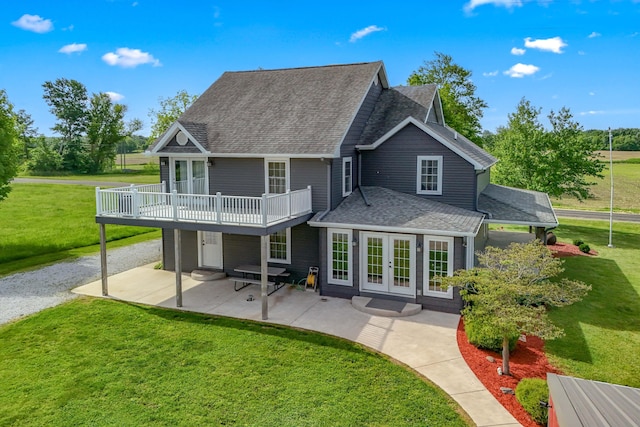 back of house with french doors, a yard, roof with shingles, and a patio area