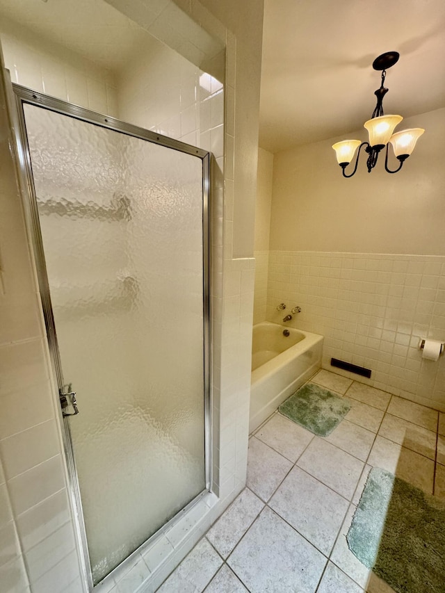 bathroom featuring independent shower and bath, tile walls, tile patterned floors, and an inviting chandelier