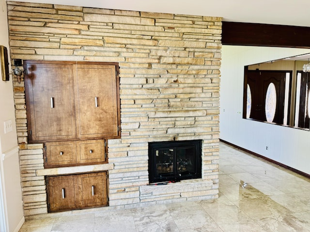 unfurnished living room featuring a stone fireplace and beamed ceiling