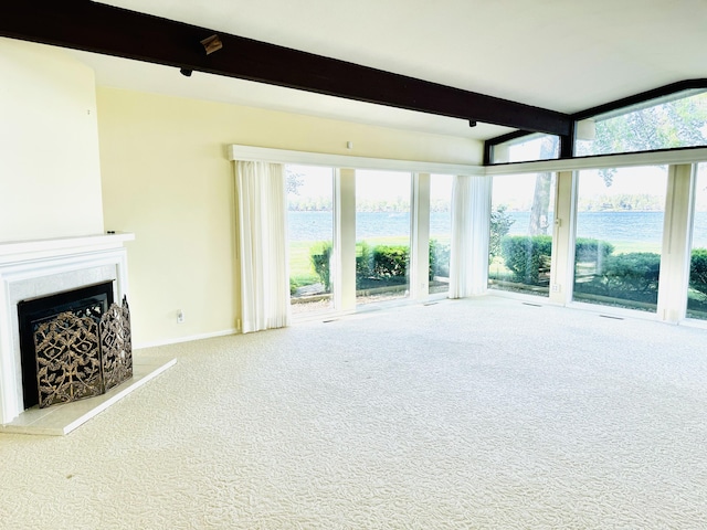 unfurnished living room featuring a water view, light colored carpet, and a wall of windows