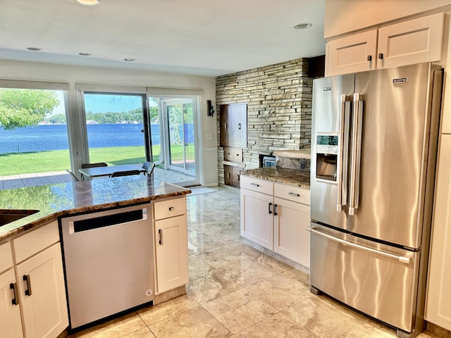 kitchen featuring white cabinetry, plenty of natural light, stainless steel appliances, and stone countertops