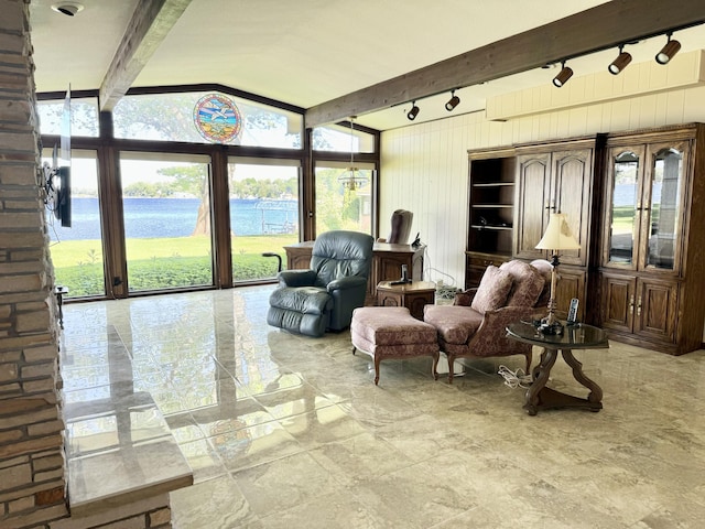 sunroom with a water view, a healthy amount of sunlight, and beam ceiling