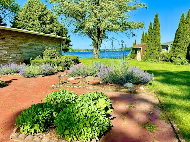 view of yard featuring a storage unit and a water view