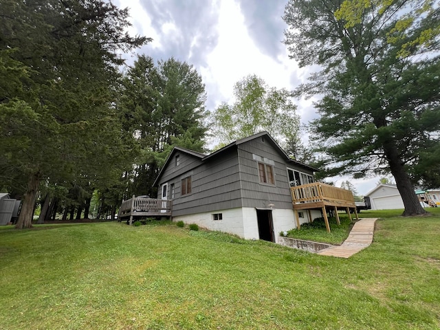 view of side of property featuring a deck, a garage, and a lawn