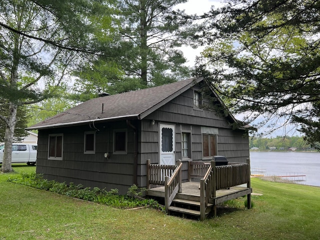 view of front of house with a front lawn and a deck with water view