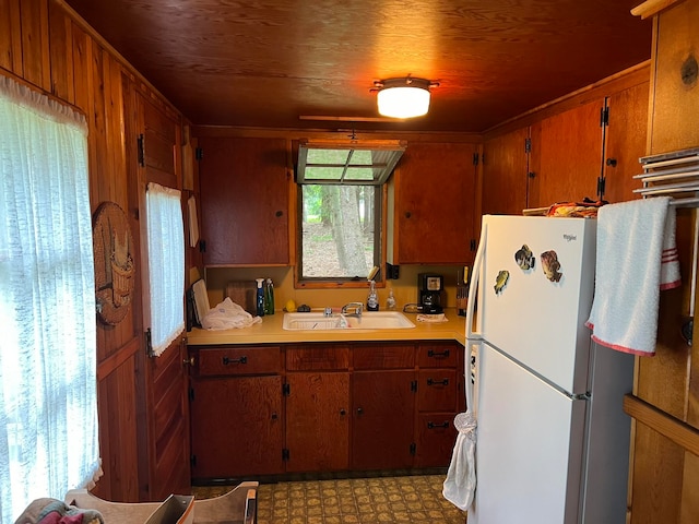 kitchen with tile floors, sink, and white fridge