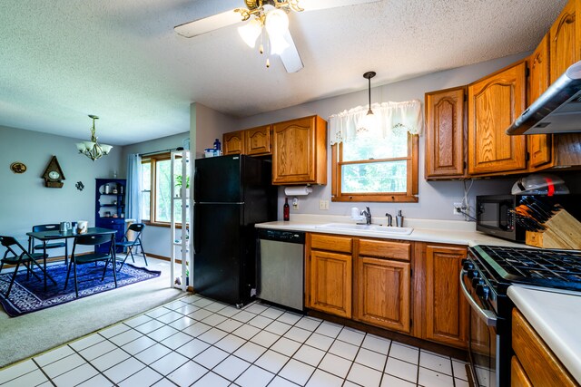 kitchen featuring hanging light fixtures, a wealth of natural light, and black appliances