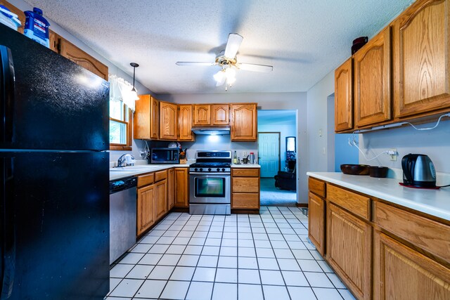 kitchen featuring a textured ceiling, stainless steel appliances, ceiling fan, sink, and hanging light fixtures