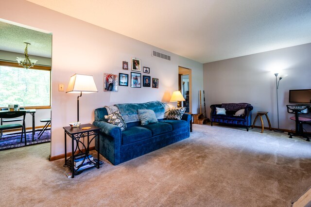 carpeted living room featuring a notable chandelier