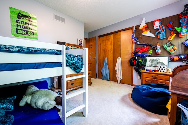 bedroom with a closet, light colored carpet, and a textured ceiling