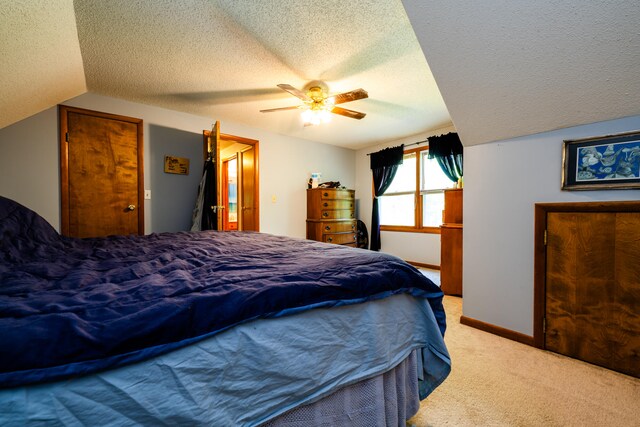 bedroom with carpet, a textured ceiling, ceiling fan, and lofted ceiling