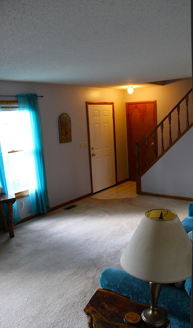 carpeted entryway featuring a textured ceiling