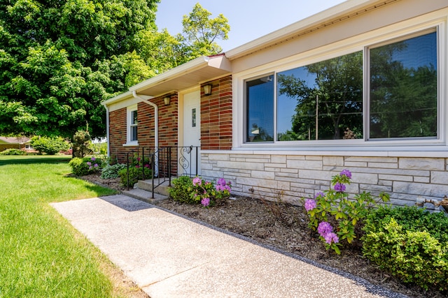 view of exterior entry with a lawn