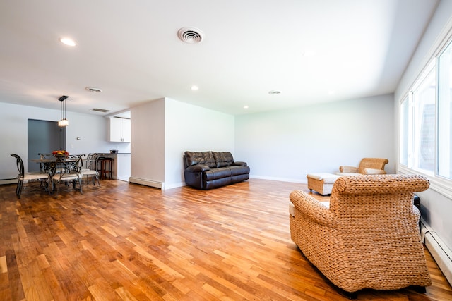 living room with light hardwood / wood-style floors and baseboard heating