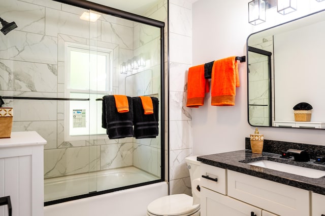 full bathroom with vanity, toilet, bath / shower combo with glass door, and tile walls