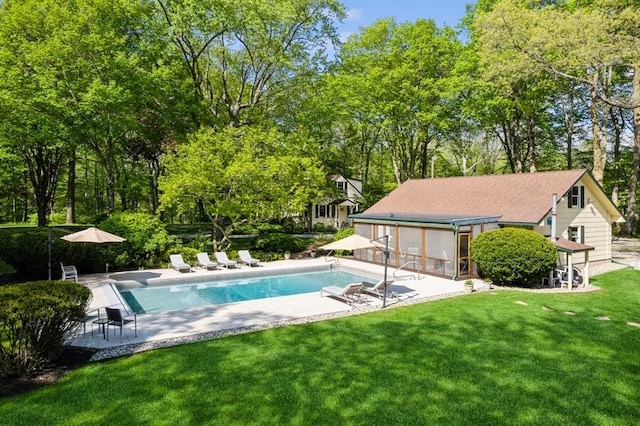 view of pool featuring a lawn, a patio area, and a sunroom