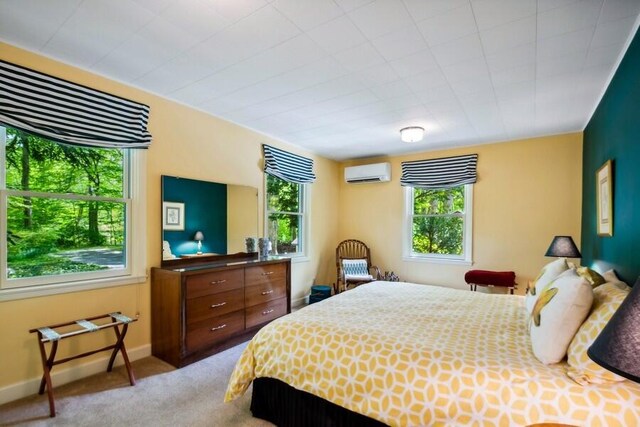 bedroom featuring light colored carpet and an AC wall unit