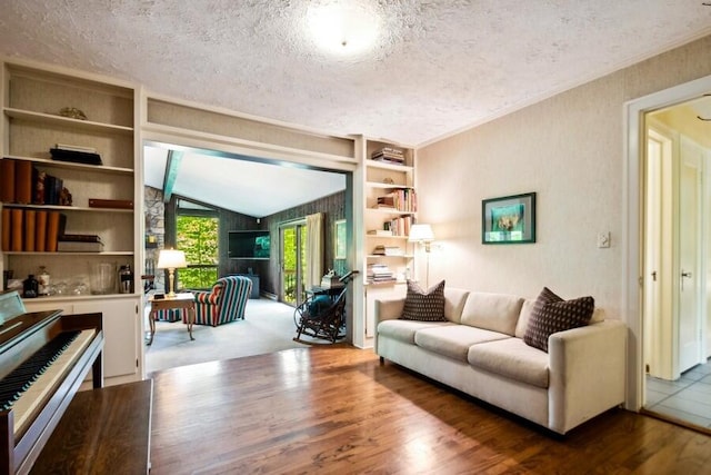 living room with built in features, wood-type flooring, lofted ceiling, and a textured ceiling