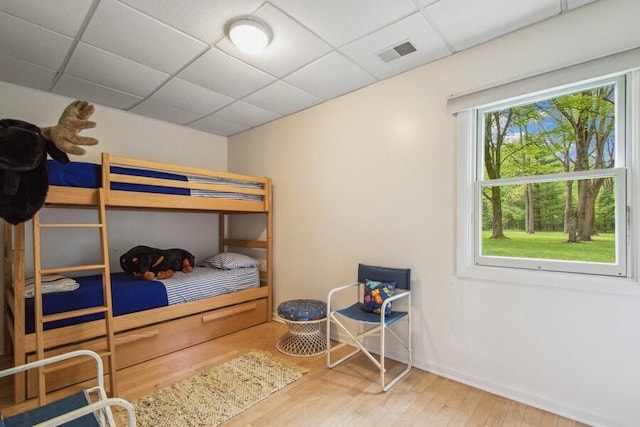 bedroom with hardwood / wood-style flooring and a paneled ceiling