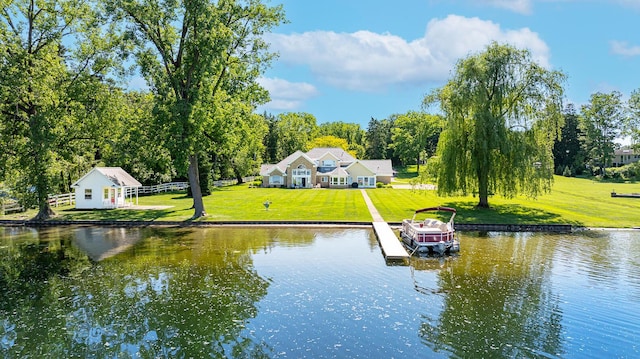 view of dock with a yard and a water view