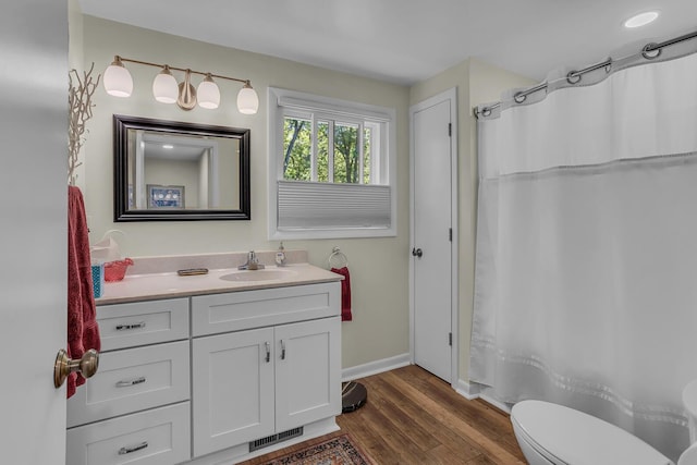 bathroom with vanity, hardwood / wood-style flooring, and toilet