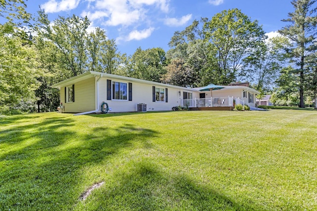 back of property featuring a wooden deck, a yard, and central AC