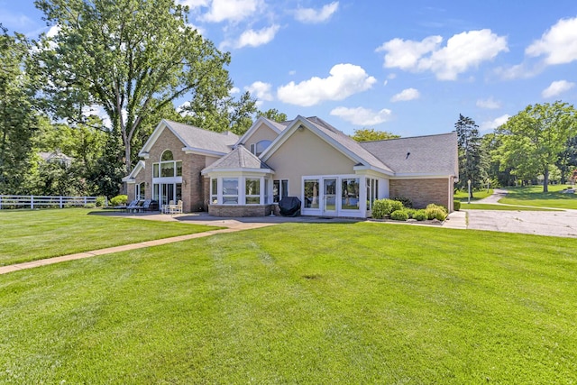 view of front of home with a front yard and french doors