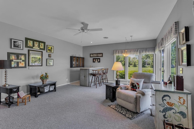 carpeted living room featuring bar and ceiling fan