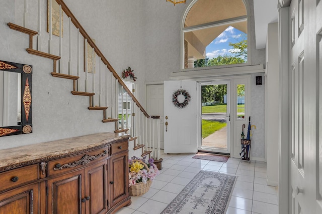 entrance foyer featuring light tile patterned floors and a towering ceiling